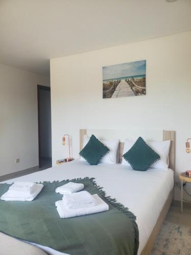 una camera da letto con un letto con asciugamani sopra di Villa Ribeiro a Vila Praia de Âncora