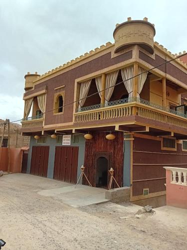 a building with a balcony on top of it at RIAD TOUBKAL D'ATLAS TIFNOUTe in Imlil