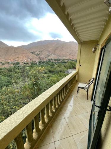 a balcony with a chair and a view of the mountains at RIAD TOUBKAL D'ATLAS TIFNOUTe in Imlil