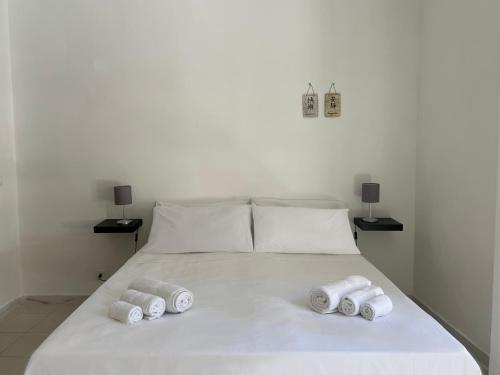 a white bed with three rolled towels on it at Taormina Seaside in Mazzeo