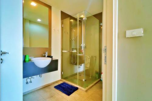 a bathroom with a glass shower and a sink at Walking Street Netflix 濒海雅居 两卧室奢华海景公寓 in Pattaya South