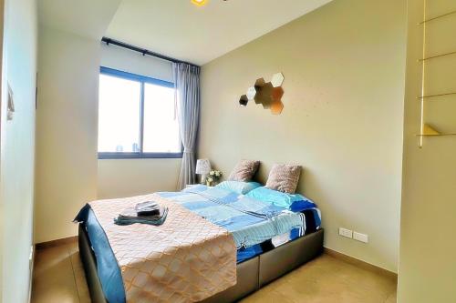 a bedroom with a bed with a blue comforter and a window at Walking Street Netflix 濒海雅居 两卧室奢华海景公寓 in Pattaya South