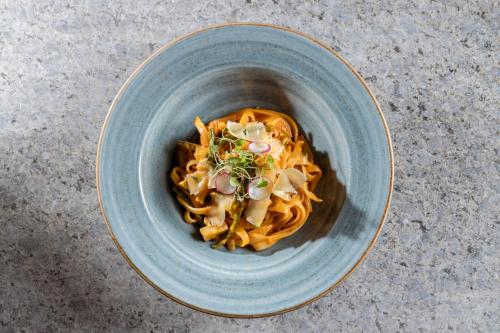 a blue bowl filled with pasta on a table at Casa del Sol Machupicchu in Machu Picchu