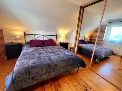 une chambre avec deux lits et un grand miroir dans l'établissement Rue des hautes lumières ouistreham Mer et campagne 3 chambres, à Saint-Aubin-dʼArquenay