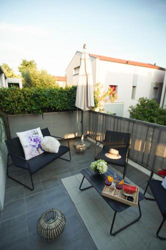 a patio with a umbrella and a table and chairs at Elly in Ankaran