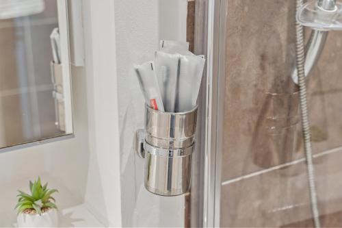 a metal holder with toothbrushes in a bathroom door at Golden Desert with FREE Parking - Netflix in Birmingham