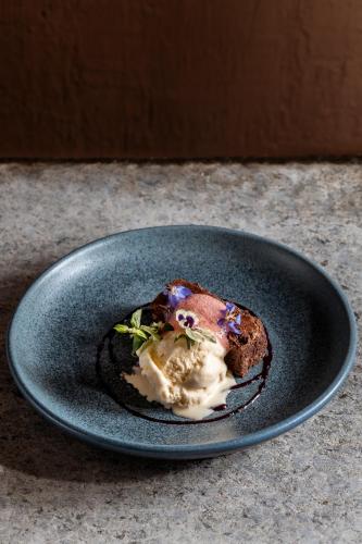 a blue plate with a piece of bread with ice cream at Casa del Sol Machupicchu in Machu Picchu