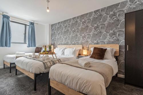 a bedroom with two beds and a stone wall at Golden Desert with FREE Parking - Netflix in Birmingham