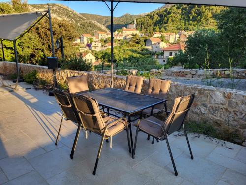a table and chairs on a patio with a view at Apartments Pitve in Jelsa