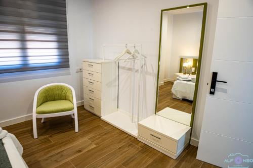 spogliatoio con specchio e sedia di Alojamientos VEN -Vista Extremadura Norte a Plasencia