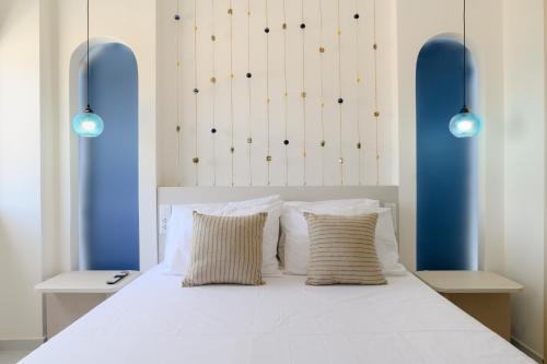 a bedroom with a white bed with two pillows at Mylos Luxury Escape Villa in Faliraki
