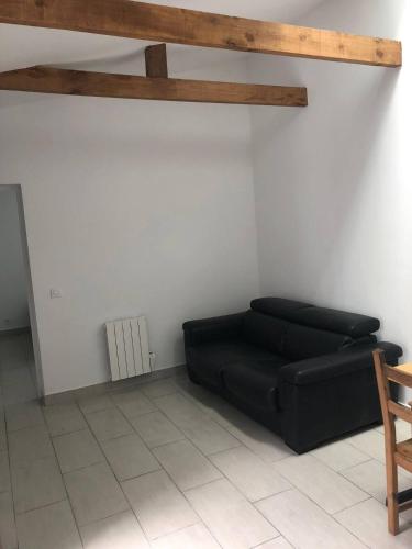 - un canapé en cuir noir dans une pièce avec plafond dans l'établissement Spacieux T2, à Colombes
