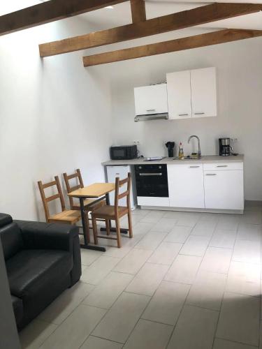 Il dispose d'une cuisine et d'un salon avec un canapé et une table. dans l'établissement Spacieux T2, à Colombes
