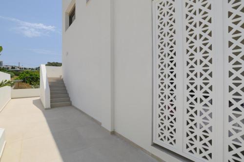 a white wall with a patterned door on a building at Mylos Luxury Escape Villa in Faliraki