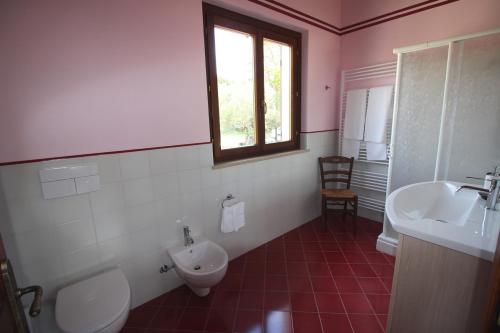 a bathroom with a toilet and a sink and a window at Agriturismo L'Arcadia in Citta' Sant'Angelo