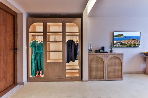 a dressing room with a closet with a wooden door at Boutique hotel Ruzmarin SPA & Garden by Aycon in Budva