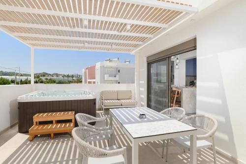 a balcony with a table and chairs and a hot tub at Mylos Luxury Escape Villa in Faliraki