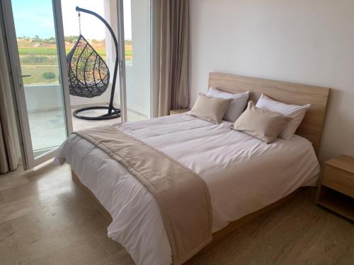 布兹尼盖Appartement de luxe avec vue sur mer的一间带大床和大窗户的卧室