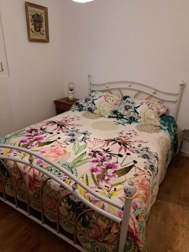 une chambre avec un lit avec un couvre-lit fleuri dans l'établissement Le temps de vivre, à Baron