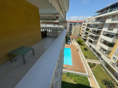 Cet appartement dispose d'un balcon avec une piscine et des bâtiments. dans l'établissement Elegant Apartment with Sea View and Swimming pool, à Nice