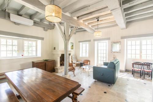 - un grand salon avec une table et des chaises en bois dans l'établissement Château de Conon gîte La Bergerie, à Cellettes