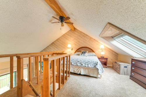 ein Schlafzimmer im Dachgeschoss mit einem Bett und einem Dachfenster in der Unterkunft Bellaire Ski Condo 1 Mi to Summit Mountain! in Bellaire