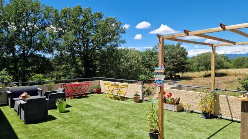a garden with chairs and a pergola at Les 3 Chênes in Puechredon