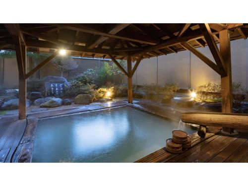 a large swimming pool under a pavilion with a table at Yuinosato Azumakan - Vacation STAY 03246v in Nihommatsu