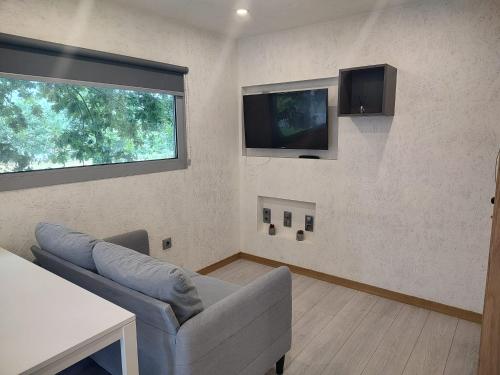 a living room with a couch and a flat screen tv at Cantinho de Trevoeiros - Casa Duarte in Arcos de Valdevez