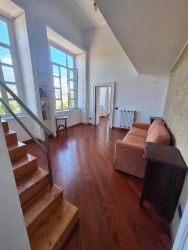 a large living room with a couch and a staircase at La Casa di Mary in Ercolano