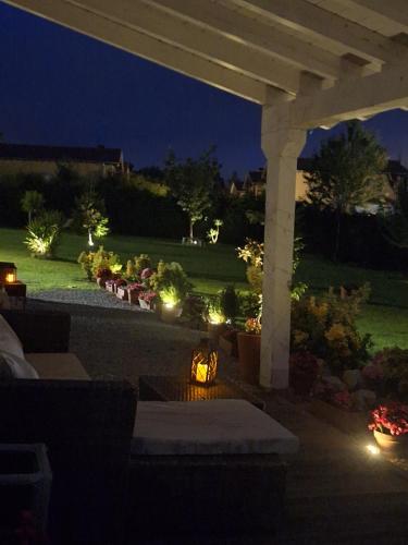 a patio with a fire pit under a pergola at night at La buganvilla en Udias alojamiento in Comillas