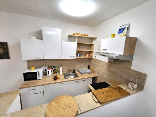 a small kitchen with white cabinets and a sink at Apartments Pitve in Jelsa