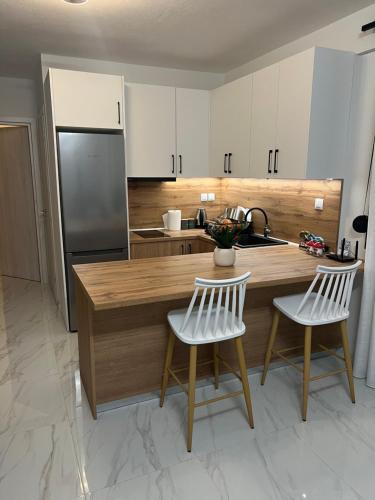 a kitchen with a wooden counter and white cabinets at Ioannis Villa in Nea Fokea