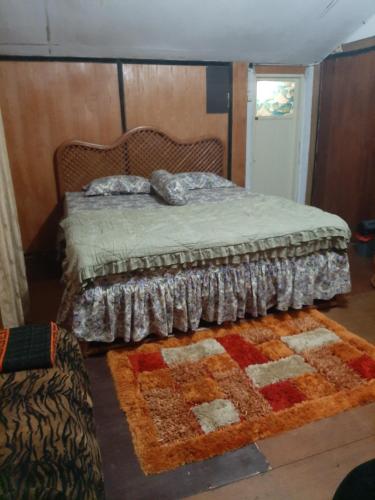 a bedroom with a bed and a rug on the floor at Dian Rana Bungalow Lampuuk in Lamgire