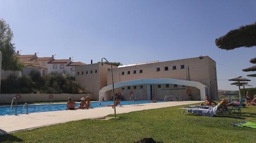 un gruppo di persone seduti intorno alla piscina di Casa Cantinero 1 - Parking Gratis ad Ardales