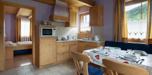a kitchen with a table and chairs and a kitchen with a tableablish at Residence Le Cascate in Livigno