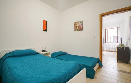 Un dormitorio con una cama con un edredón azul. en Casa Fiorella, en Taggia