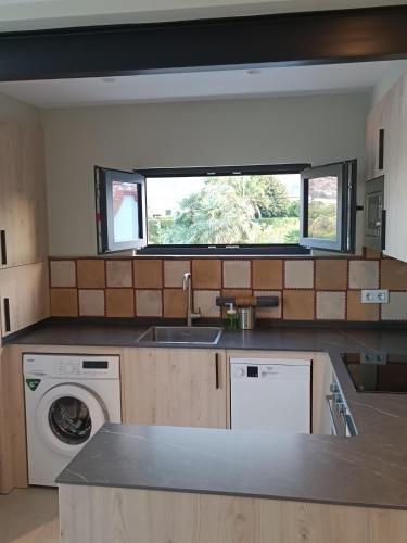 a kitchen with a sink and a washing machine at La Cambreta in Pedreguer