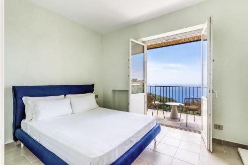 a bedroom with a bed and a view of the ocean at Le Arcate Sea La Vie by Feeling Italy in Massa Lubrense