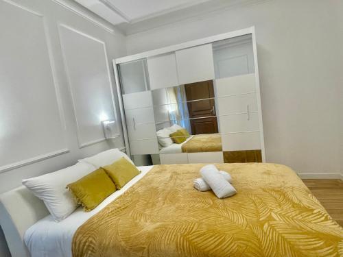 une chambre avec un grand lit avec des oreillers jaunes et blancs dans l'établissement Luxury apartement, près de Musée Louvre, à Paris