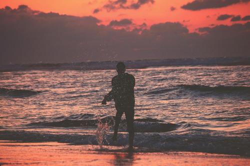 a man standing on the beach watching the ocean at anza in Agadir