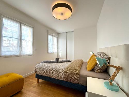 - une chambre avec un lit et une lampe dans l'établissement L Eiffel Disney 5min Paris 35min Parking Terrasse, à Serris