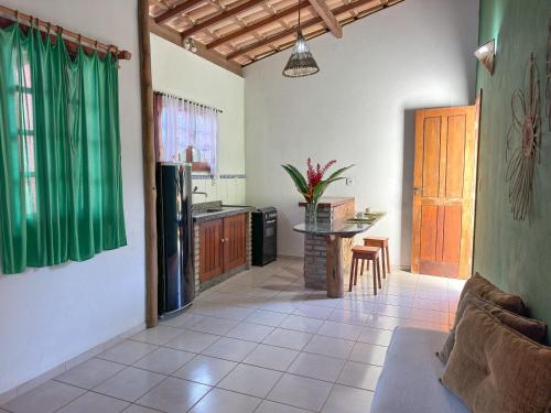 a living room with a table and a kitchen at Flat Barra in Barra Grande