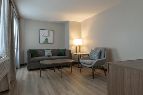 a living room with a couch and a chair at Holiday Inn St-Jean-sur-Richelieu Congrès by IHG in Saint-Jean-sur-Richelieu