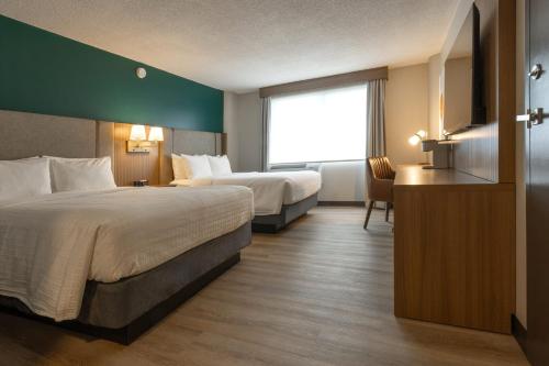 a hotel room with two beds and a window at Holiday Inn St-Jean-sur-Richelieu Congrès by IHG in Saint-Jean-sur-Richelieu