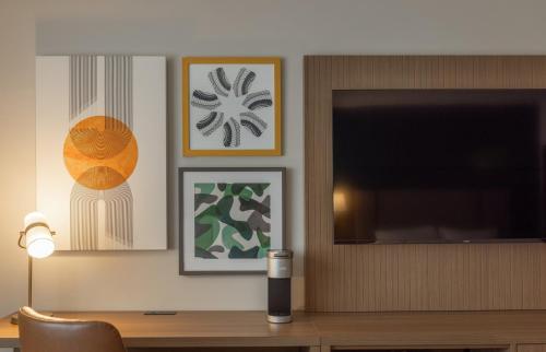 a room with a desk with a tv and a lamp at Holiday Inn St-Jean-sur-Richelieu Congrès by IHG in Saint-Jean-sur-Richelieu