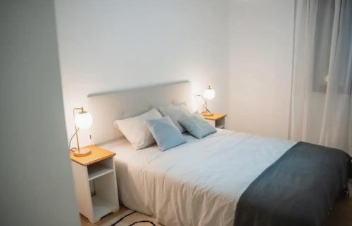 a bedroom with a large white bed with two lamps at Ondas do Mar Boutique Stays - Portonovo 2 in Portonovo