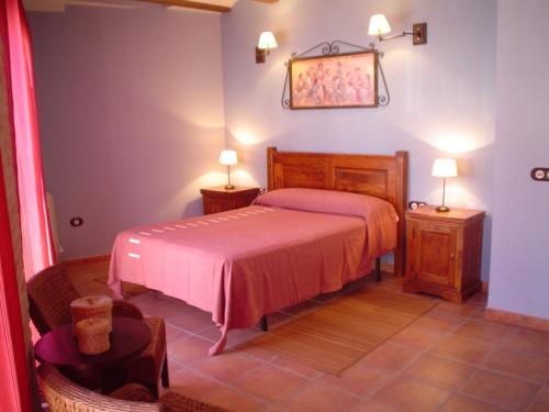 1 dormitorio con 1 cama y 2 mesitas de noche con lámparas en Apartamentos Turísticos Pepe, en Gea de Albarracín