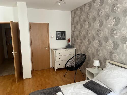 a bedroom with a bed and a chair and a dresser at Peter's Cosy Budapest Suite in Budapest