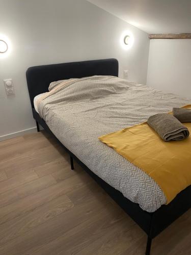 une chambre avec un lit avec une couverture jaune dessus dans l'établissement Le cosy duplex avec jardin à Poitiers, à Poitiers